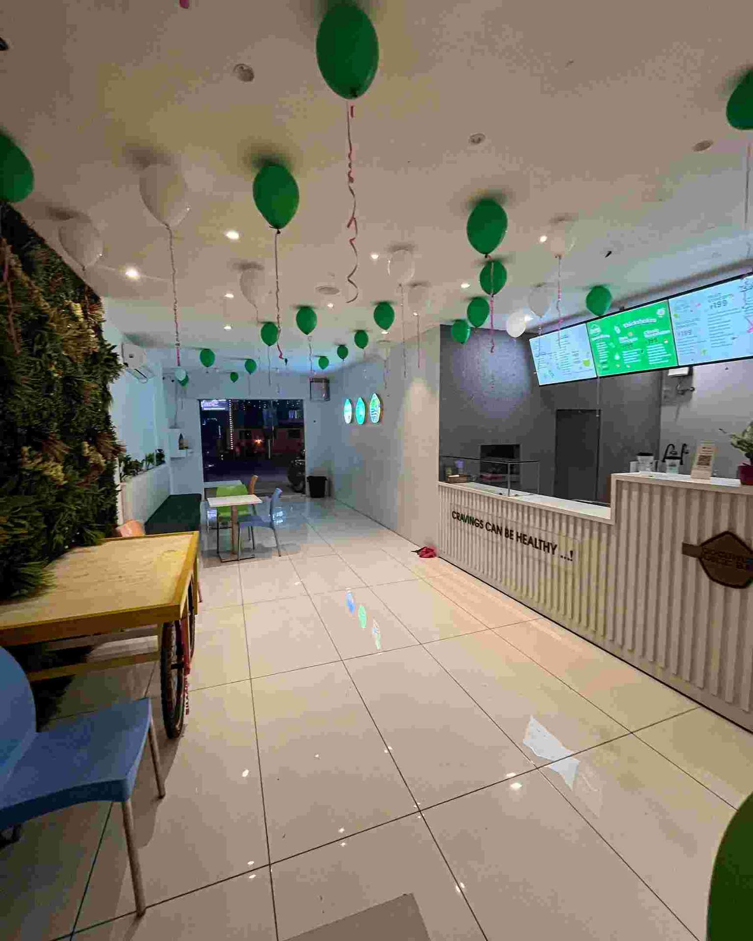 Modern juice bar interior with green balloon decorations